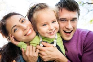 family smiling with beautiful smiles and blue eyes
